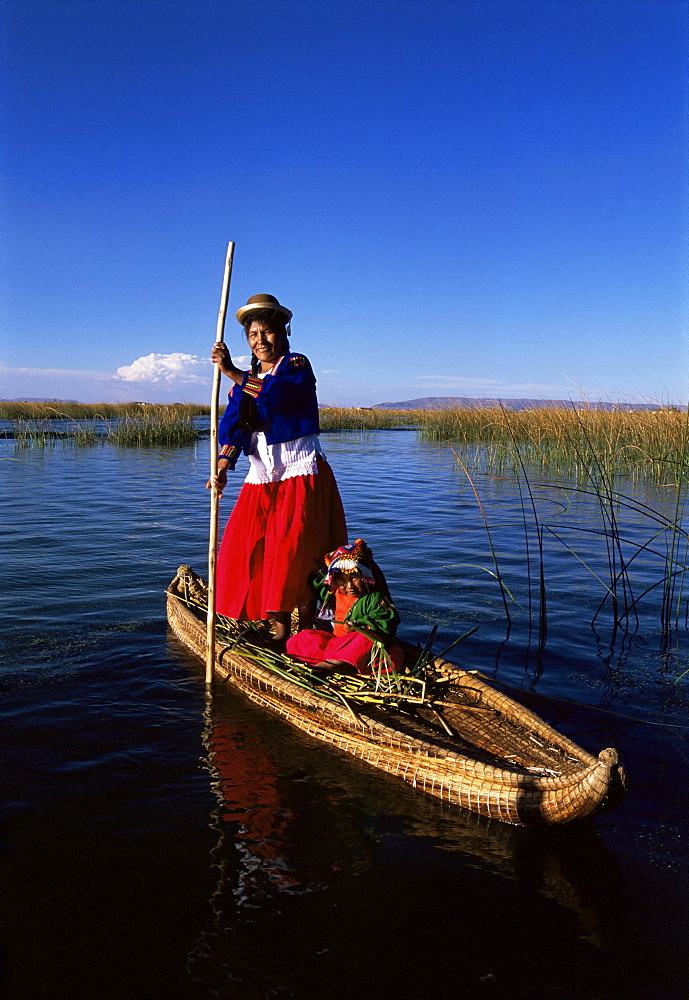 Uros Indian woman and traditional reed boat, Islas Flotantes, Lake Titicaca, Peru, South America