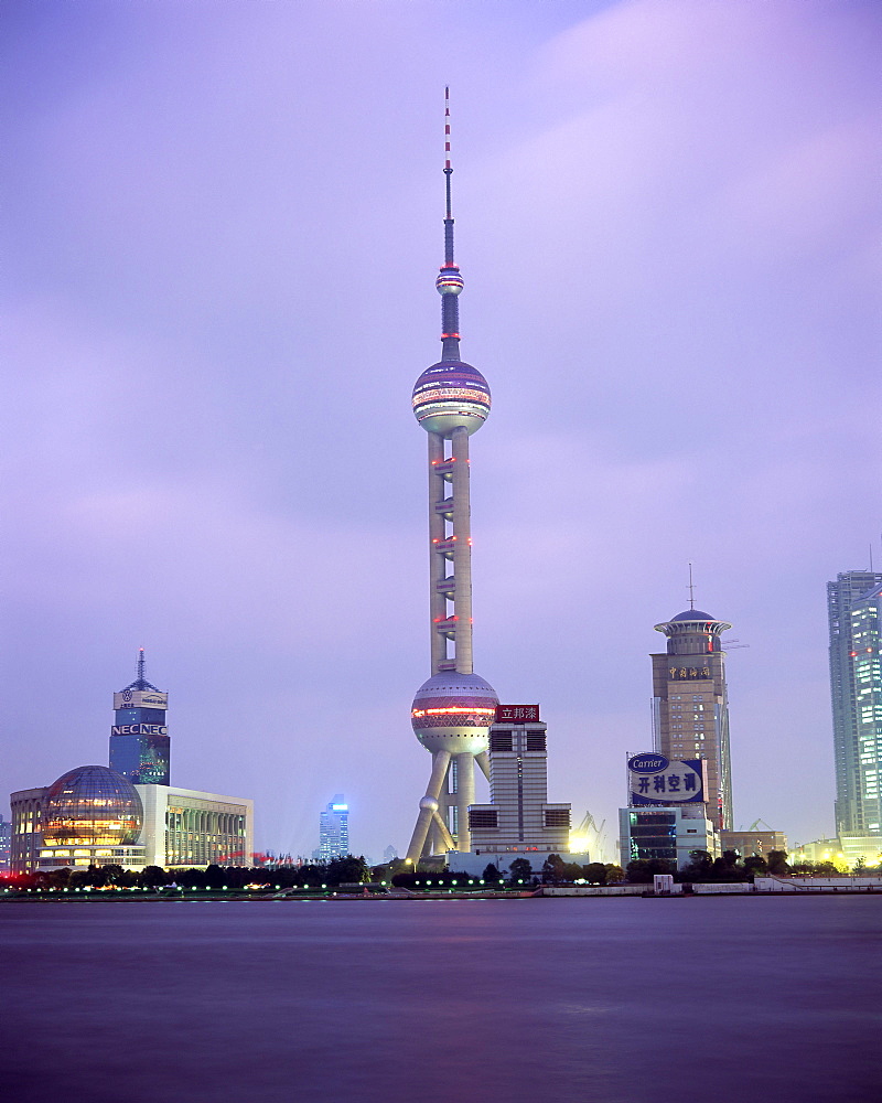 View across river at dusk to the new Pudong district skyline, Huangpu River, Shanghai, China, Asia