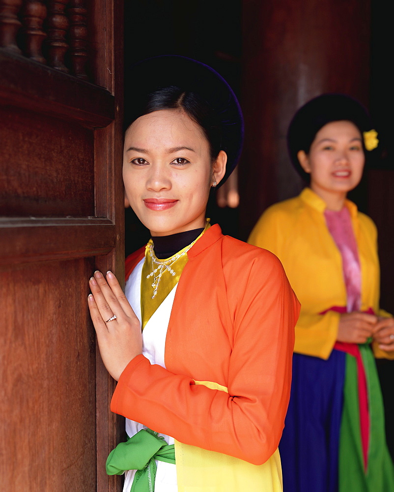 Two smiling Vietnamese women in traditional dress, looking at the camera, Temple of Literature, Hanoi, North Vietnam, Vietnam, Indochina, Southeast Asia, Asia