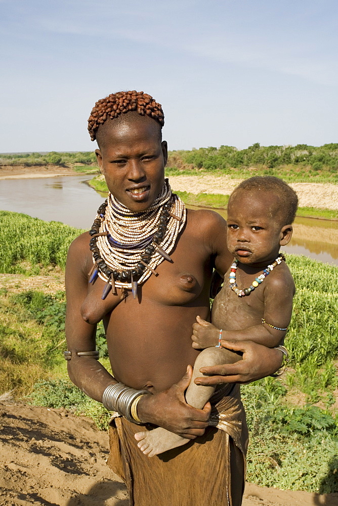 Mother and baby of the Hamer tribe, the woman's hair is treated with ochre, water and resin then twisted into tresses called goscha, Lower Omo Valley, Ethiopia, Africa