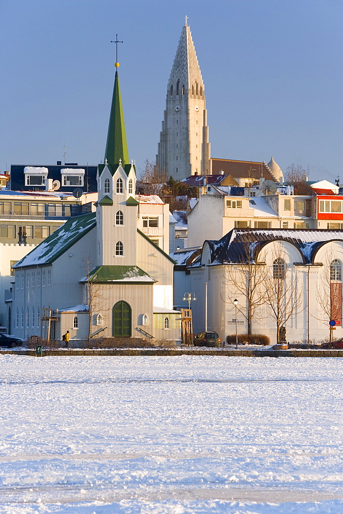 Frikirkjan church and Hallgrimskirkja church, Lake Tjorn frozen in winter, Reykjavik, Iceland, Polar Regions