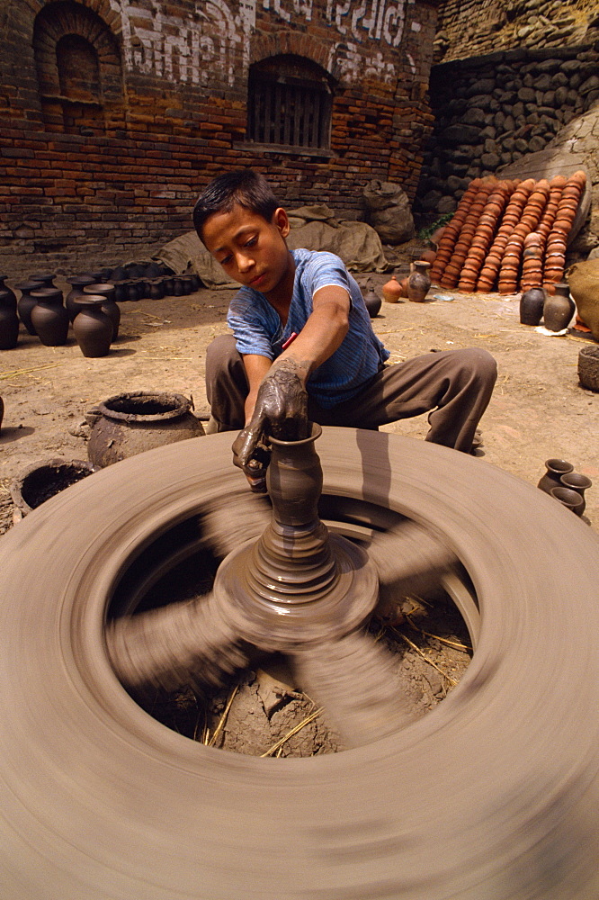 Young boy throwing a pot, Potter's Square, Bhaktapur, Nepal, Asia