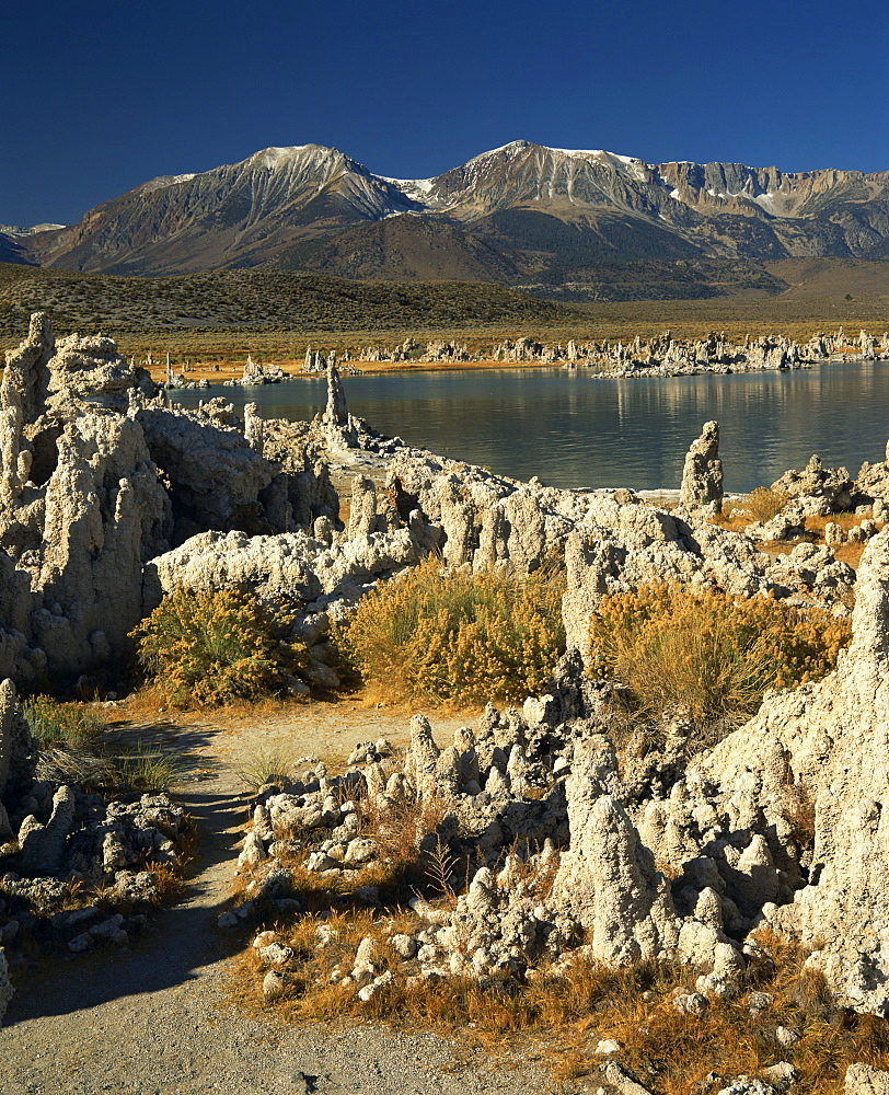 Tufas of calcium carbonate surround lake in Mono Lake Tufa State Reserve, with snow capped mountains in the background, in California, United States of America, North America