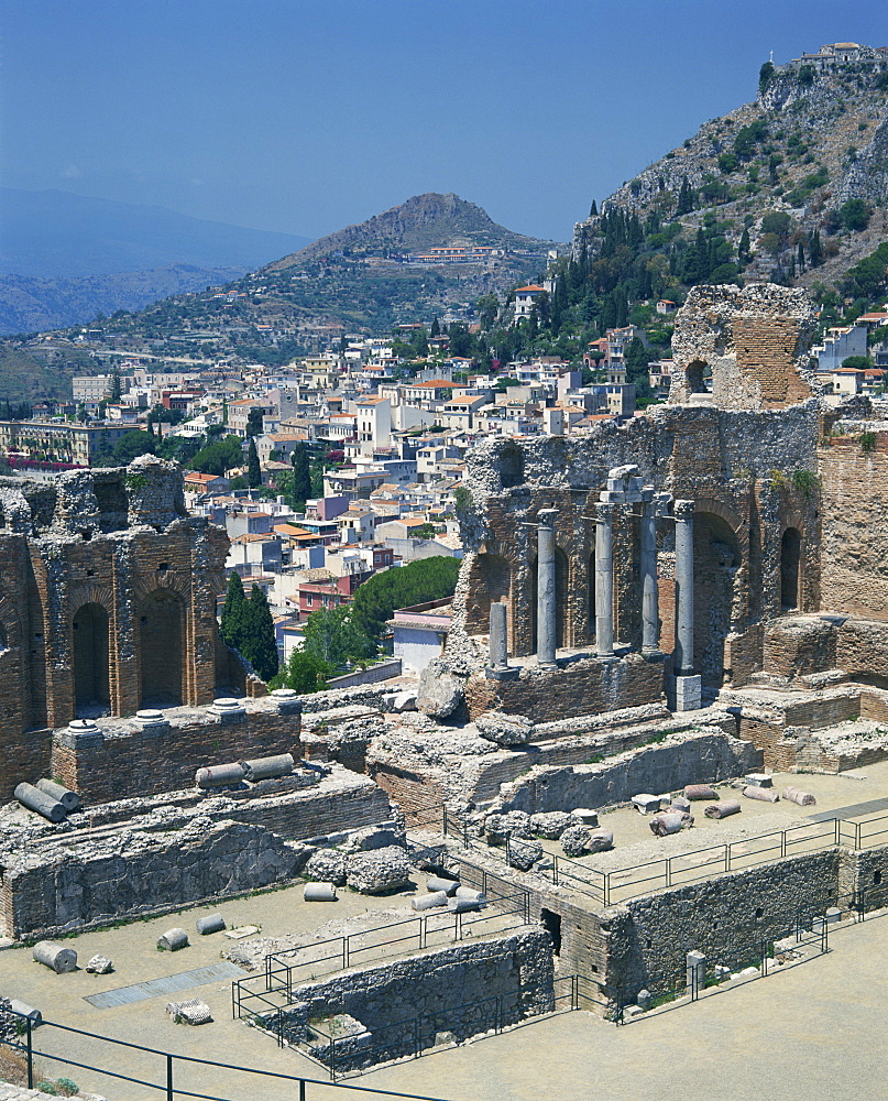 The ruins taken from the Greek Roman theatre, and the town in the background, at Taormina on the island of Sicily, Italy, Europe