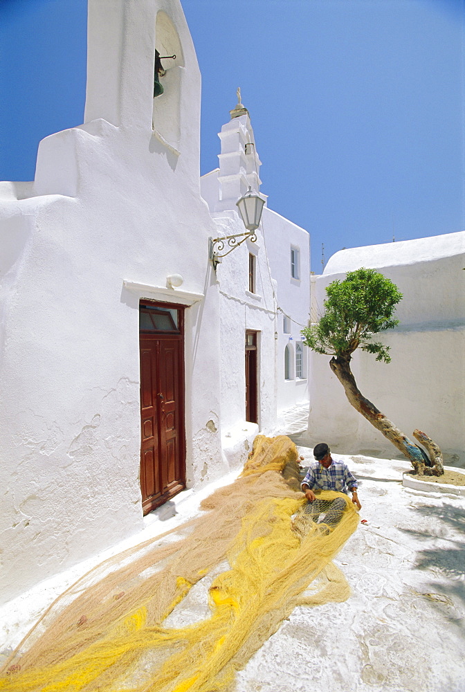 Fisherman repairing his nets, Mykonos, Cyclades Islands, Greece, Europe