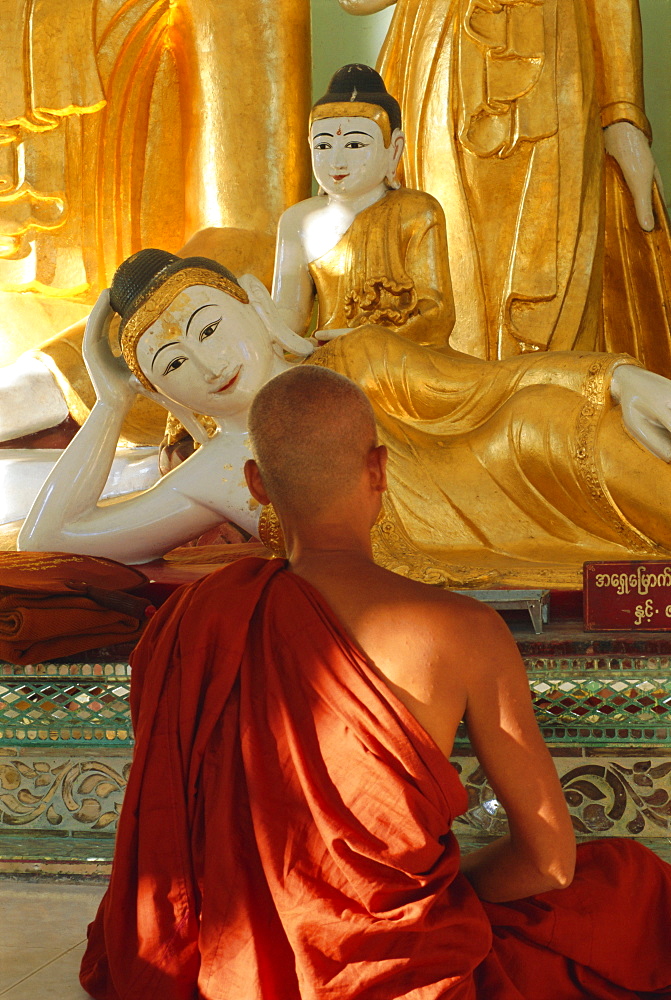 Buddhist monk worshipping, Shwedagon Paya (Shwe Dagon Pagoda), Yangon (Rangoon), Myanmar (Burma)