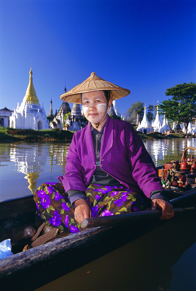 Portrait of a woman in a boat, wearing a straw hat and face paste, Phaung Daw U Kyaung, Inle Lake, Shan State, Myanmar (Burma), Asia