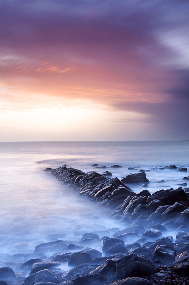 Sunset on a stormy winter's day looking across Kimmeridge Bay from the remains of Clavell's Pier, Kimmeridge, near Swanage, Dorset, England, United Kingdom, Europe