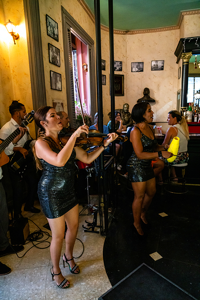 The salsa band in full flow, including female violinists, El Floridita Bar (Hemingway haunt), Havana, Cuba