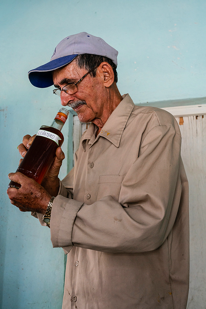 Honey producer sniffing his output, Condado, near Trinidad, Cuba (Model Release)