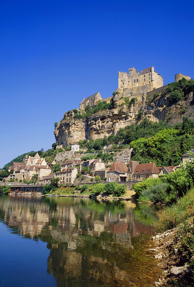 Reflections in the River Dordogne of the town and castle at Beynac, in Aquitaine, France 