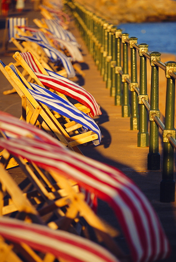 Windblown deckchairs on seafront, Sidmouth, Devon, England