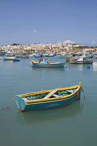 Brightly coloured fishing boats called Luzzus at the fishing village of Marsaxlokk, Malta, Mediterranean, Europe