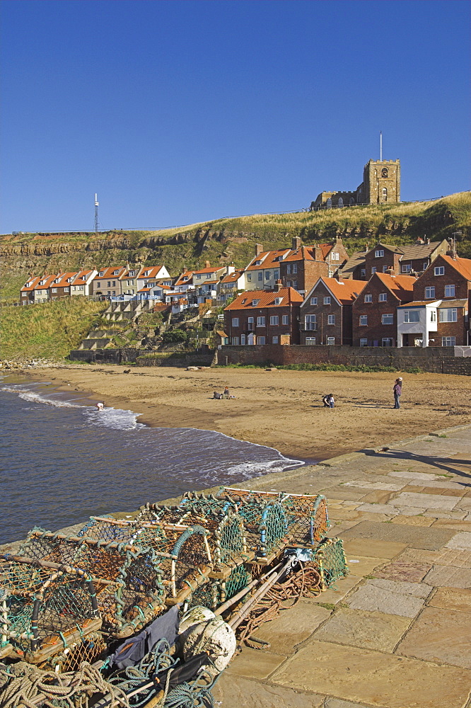 Whitby church, sandy beach and lobster pots on quayside, Whitby, North Yorkshire, Yorkshire, England, United Kingdom, Europe