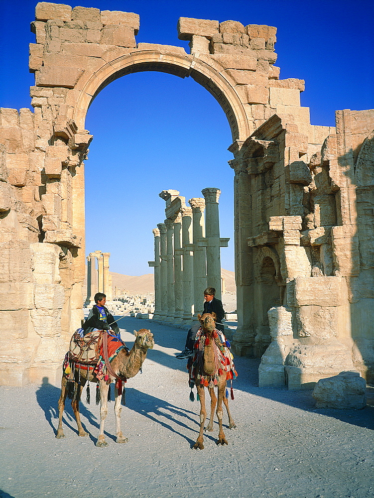 Syria, Palmyra Oasis, The Roman City Ruins, Gate Entering The 1200m Columnade Edging The Cardo (Main Road In The Roman Cities Center), Camel Riders On The Road