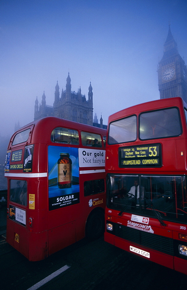 Two double decker buses passing on Westminster Bridge on a misty day, London, England, UK, Europe