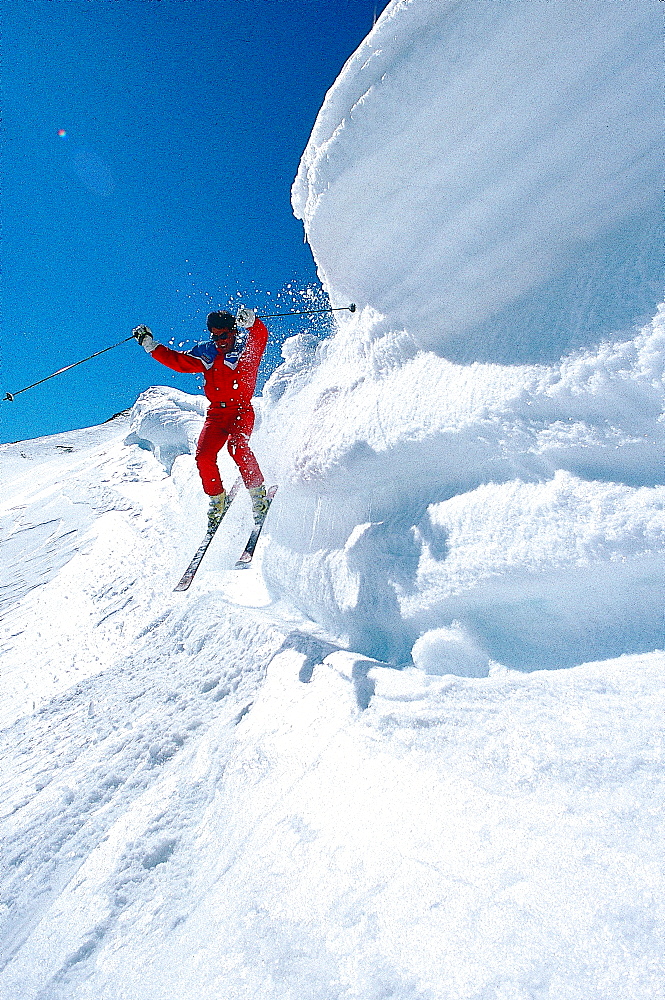 France, Alps In Winter, Haute Savoie, Megeve, Skier Jumping From A Snow Corniche 