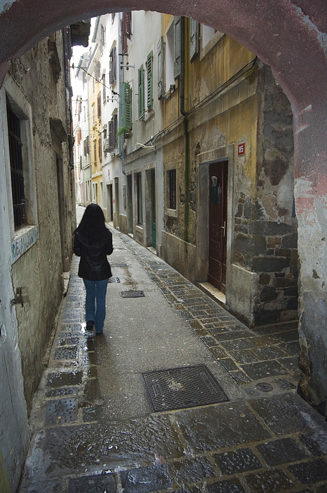 Girl walking through old street, Piran, Slovenia, Eastern Europe, Europe