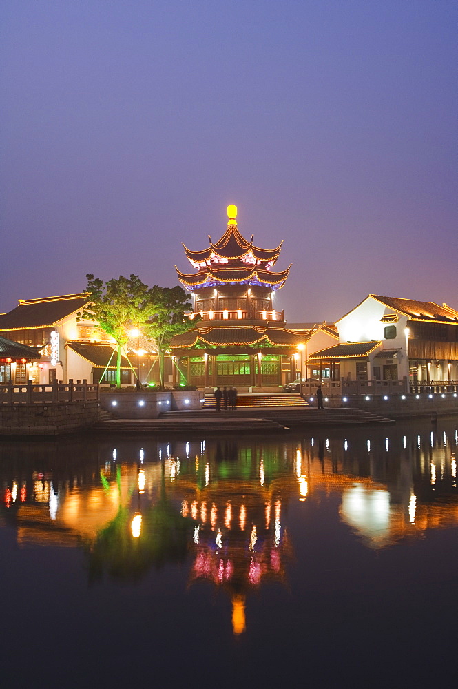 Traditional old riverside houses and pagoda illuminated at night in Shantang water town, Suzhou, Jiangsu Province, China, Asia