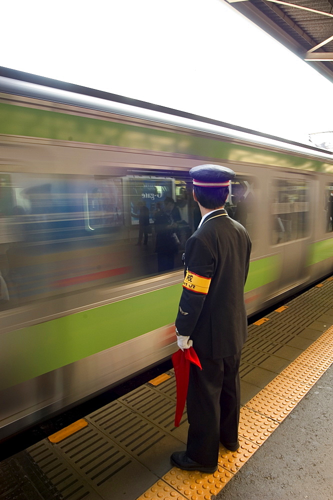 Platform conductor, subway train at rush hour, Shinjuku, Tokyo, Honshu, Japan, Asia