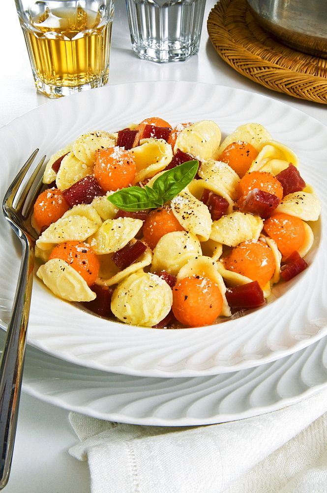 Orecchiette pasta with melon ball, prosciutto (ham), parmesan cheese and basil, Italy, Europe