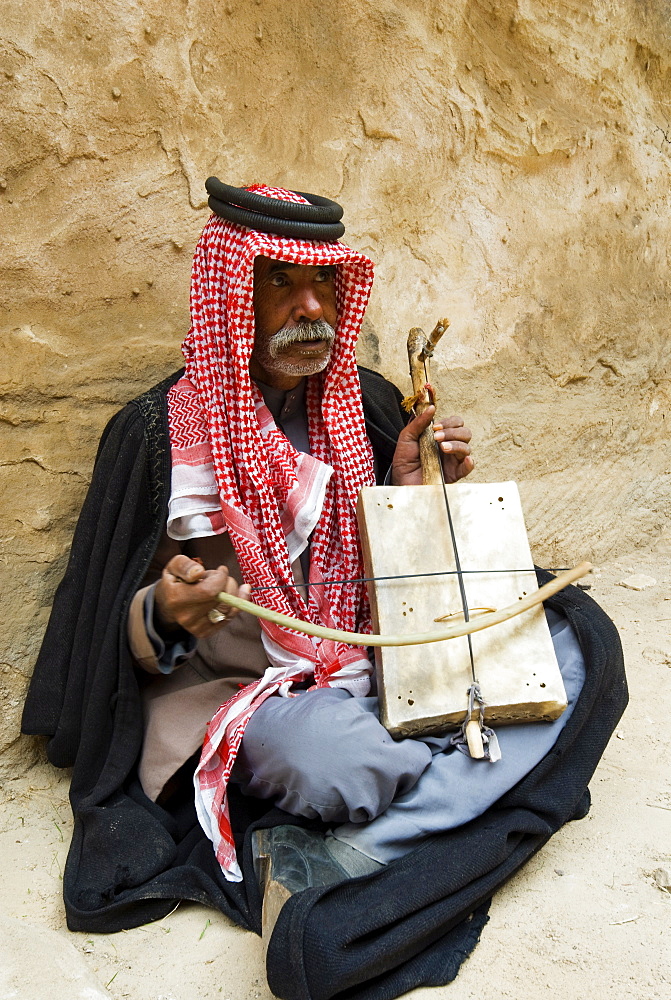 Bedouin man playing stringed instrument, Beida (Al Baidha) (Little Petra), Jordan, Middle East