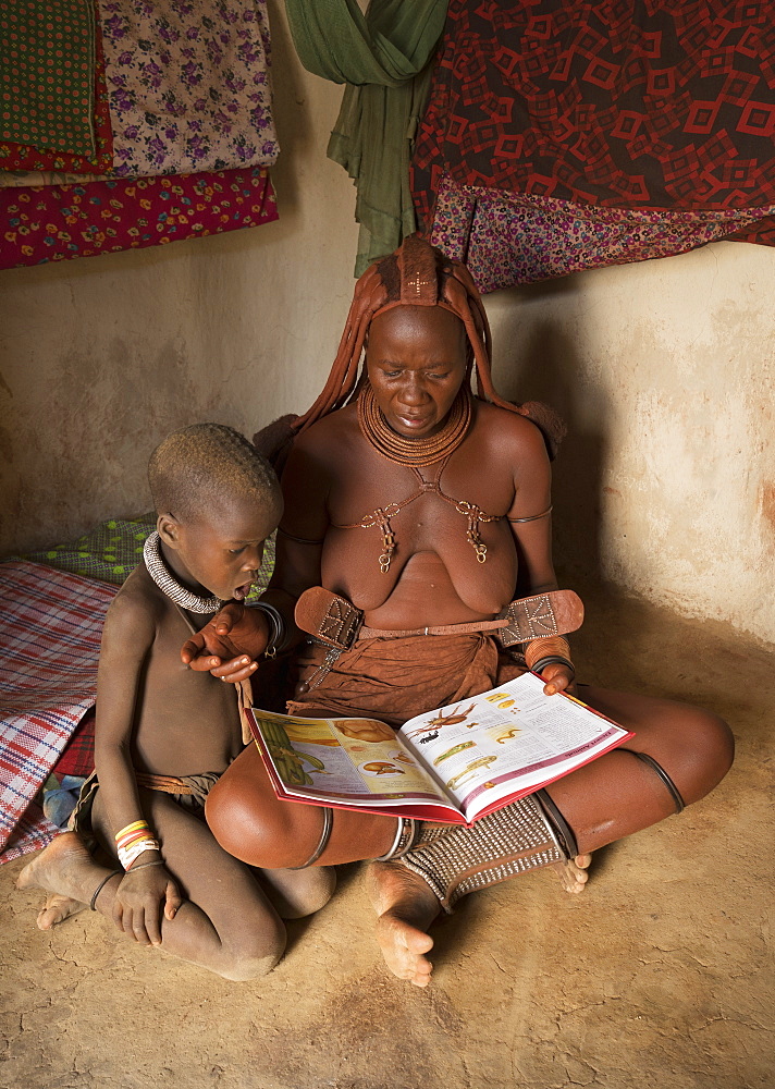 Himba woman and child reading, Kaokoland, Namibia, Africa