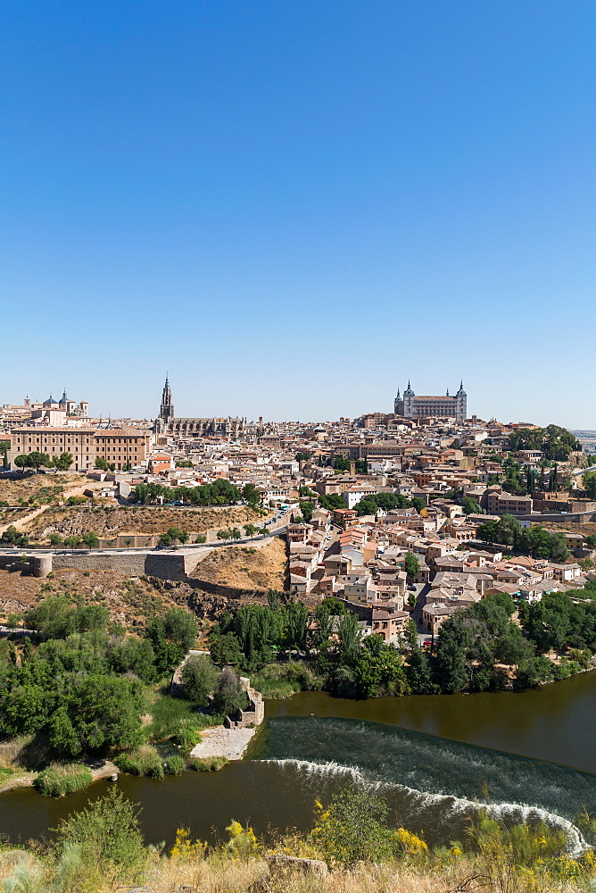 The River Tagus with the Alcazar and cathedral towering above the rooftops of Toledo, UNESCO World Heritage Site, Castilla La Mancha, Spain, Europe