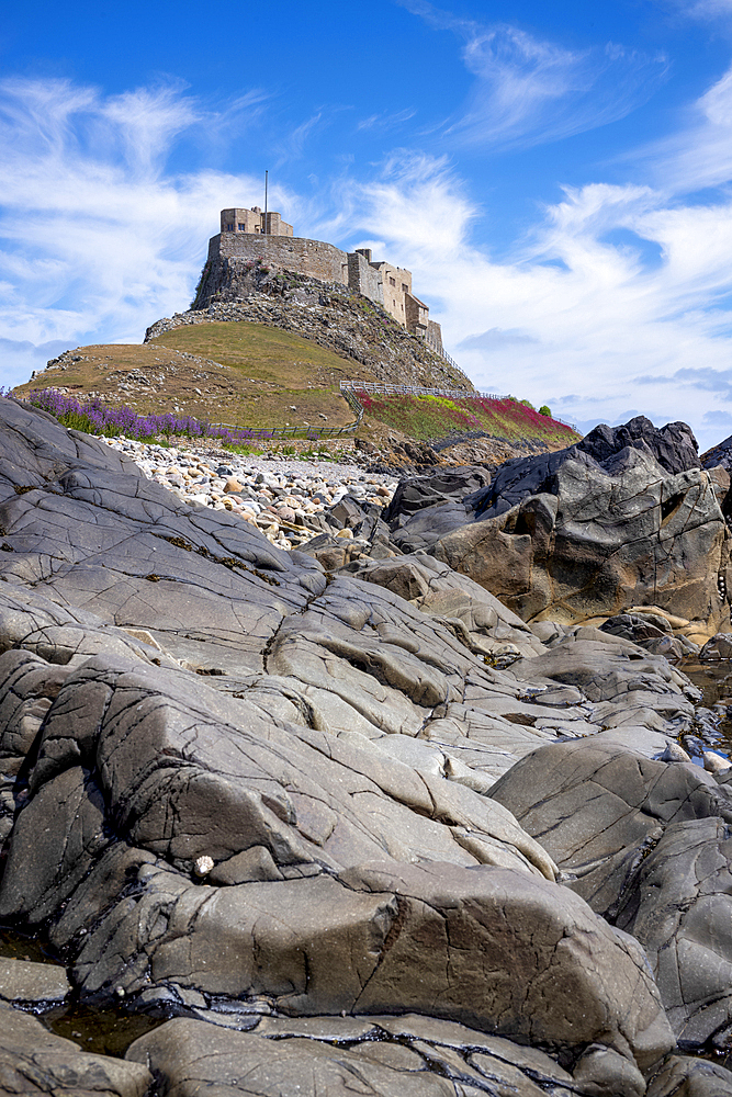 Looking up to the 16th century Lindisfarne Castle on a hillock overlooking the island of Lindisfarne, United Kingdom