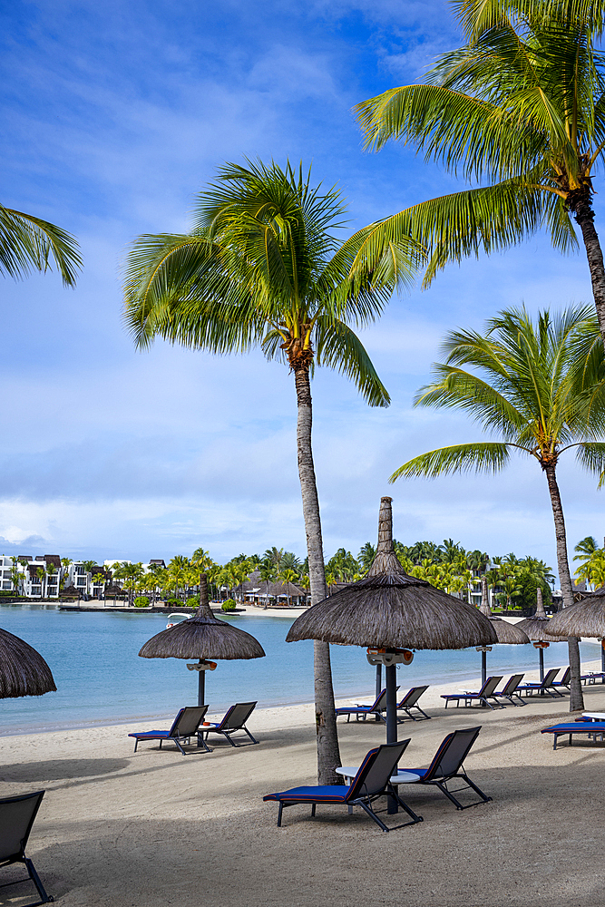 Beach with sun beds and umbrellas in Le Touessrok resort, at Trou d'Eau Douce, on the exotic island of Mauritius in the Indian Ocean