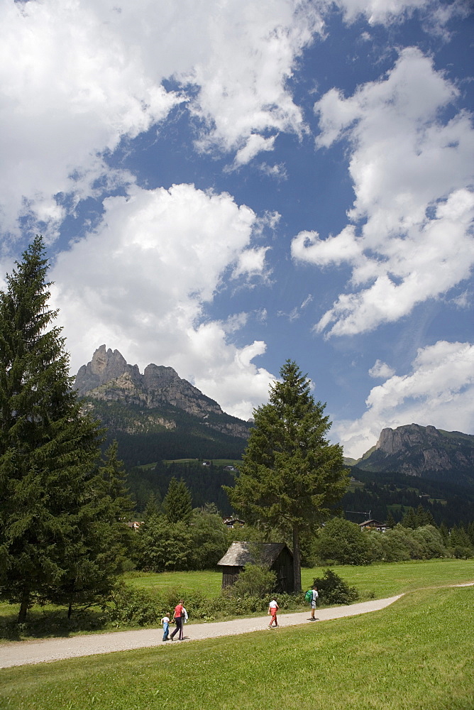 People walking along footpath in the Val de Fassa near Pera, Dolomites, Italy 