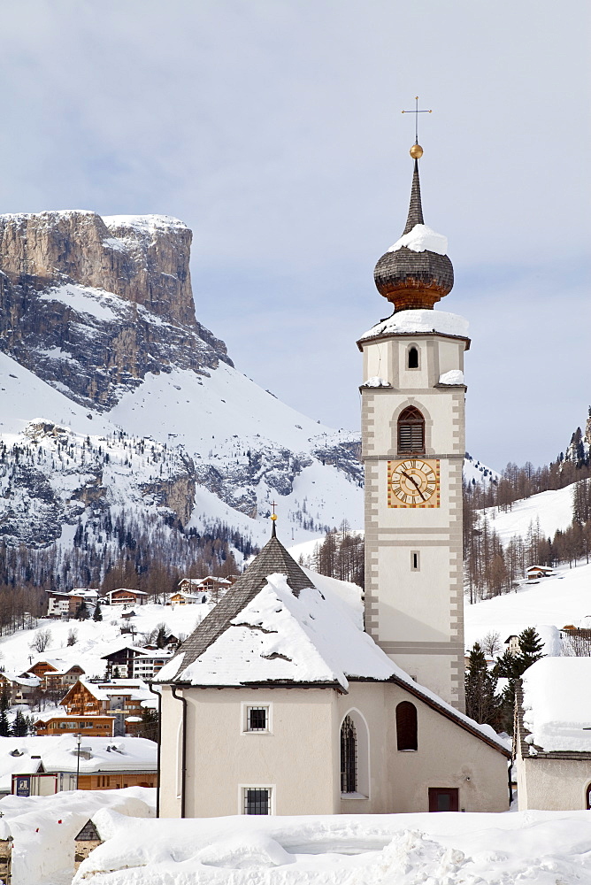 The church and village of Colfosco in Badia, 1645m, and Sella Massif range of Mountains under winter snow, Dolomites, South Tirol, Trentino-Alto Adige, Italy, Europe