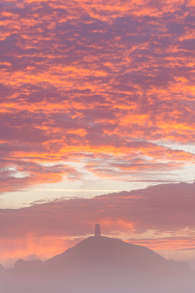 Spectacular sunrise behind Glastonbury Tor on a misty autumn morning, Somerset, England, United Kingdom, Europe