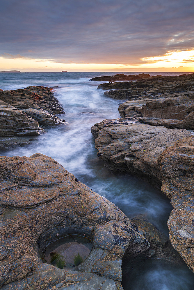 Sunset over the North Atlantic from the rocky Cornish seashore near Padstow, Cornwall, England, United Kingdom, Europe