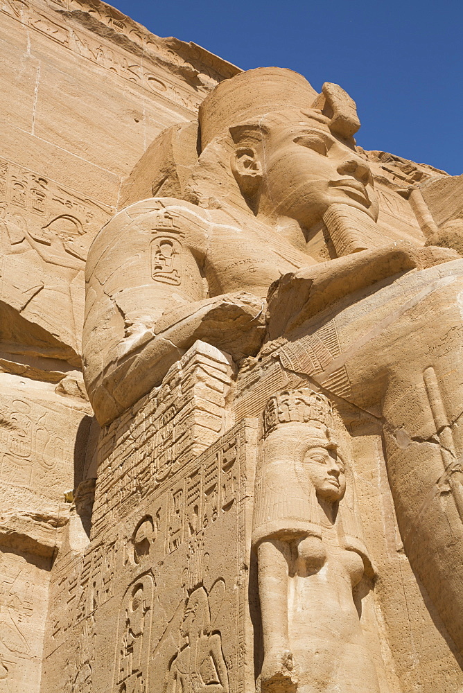 Ramses II statue with Queen Nefertari statue at lower left, Ramses II Temple, UNESCO World Heritage Site, Abu Simbel, Nubia, Egypt, North Africa, Africa