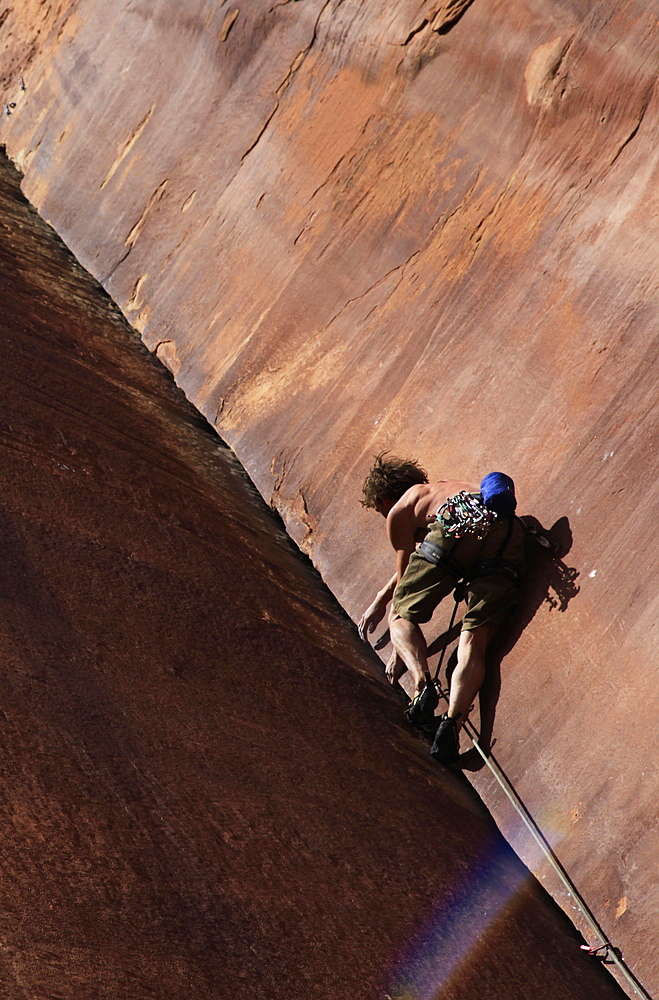 A climber tackles an overhanging corner on the cliffs of Indian Creek, a famous rock climbing area near Moab, Utah, United States of America, North America