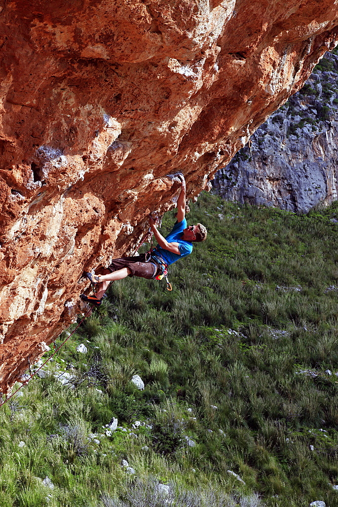 A climber scales cliffs near San Vito Lo Capo, northwest Sicily, Italy, Europe