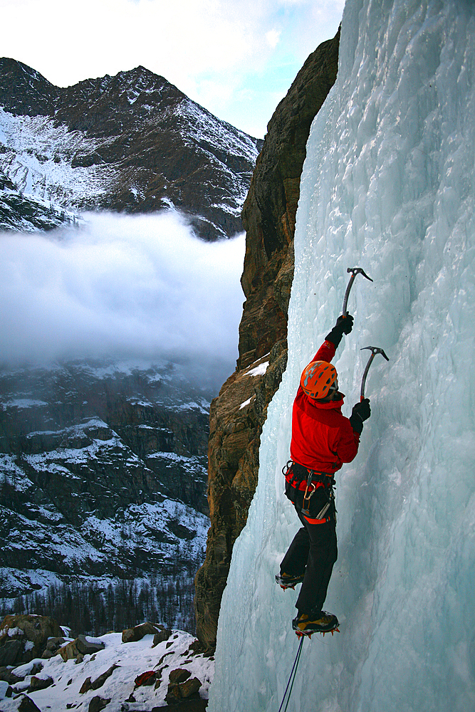 An ice climber makes his way up a frozen waterfall near Cogne, above the Aosta Valley, northern Italy, Europe