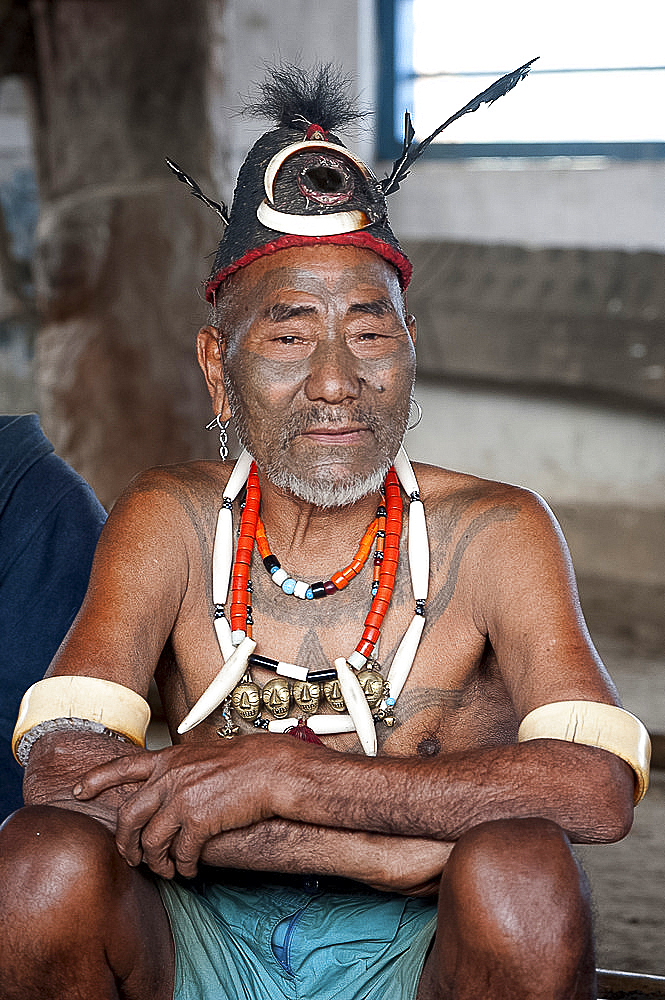 Naga head hunter, Wokshing Pensha, wearing Naga tribal necklaces and hat, and chest tattoo marking him as having taken a head, Nagaland, India, Asia