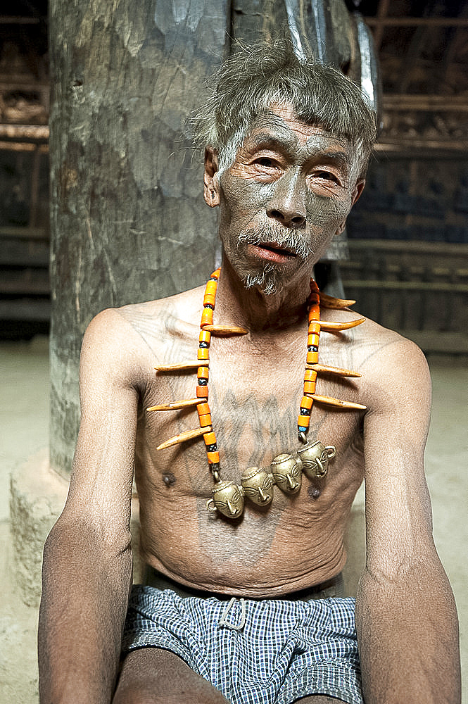 Naga headhunter, Longsha Wangnao, with chest tattoo marking him as having taken a head, and Naga necklace with tiger teeth, Nagaland, India, Asia