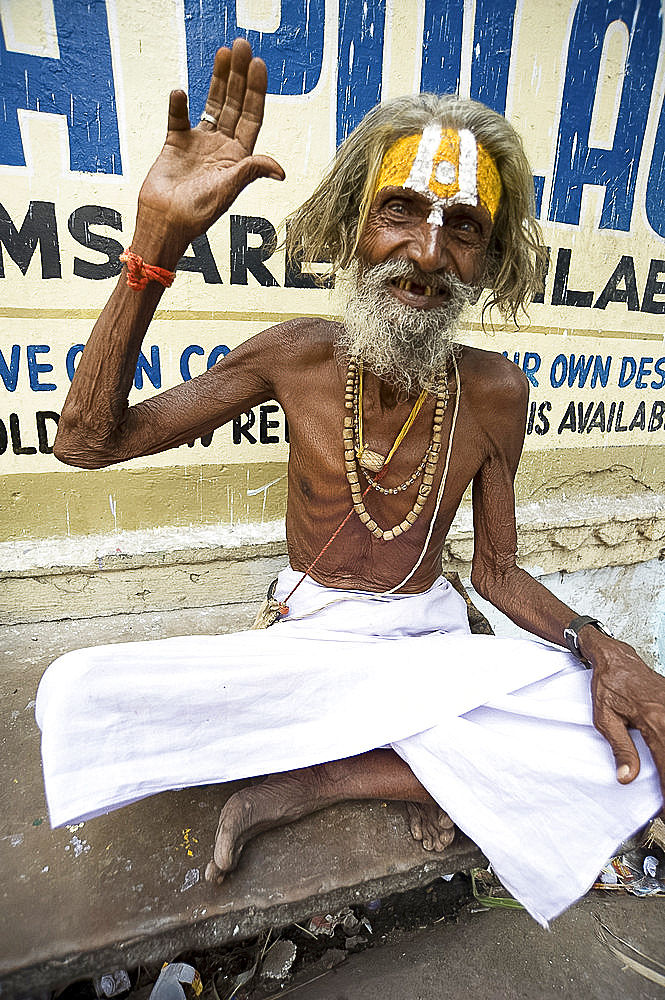 Holy man (Saddhu) with red cotton rolimoli on wrist and tilak mark on forehead denoting devotion to Hindu god Vishnu, Udaipur, Rajasthan, India, Asia