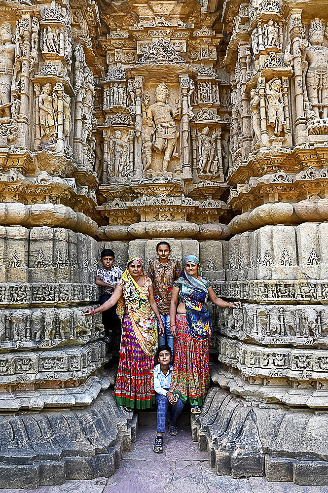 Family posing for photograph at the ornately carved Modhera Sun temple, built in 1026, Modhera, Mehsana, Gujarat, India, Asia