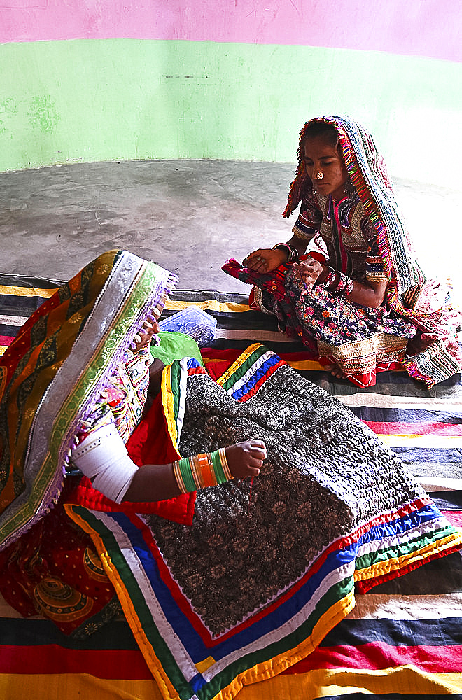 Women embroidering traditional tribal quilts in their bhunga (circular village mud house), Bhirindiara, Kutch, Gujarat, India, Asia