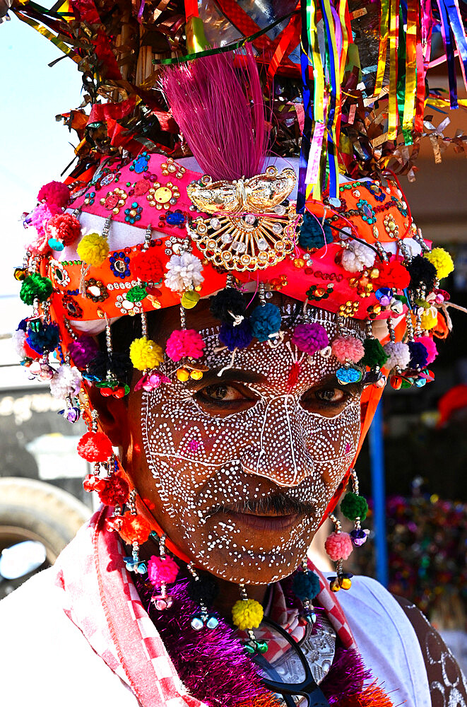 Adivasi tribal man, face decorated and wearing ornate decorated headgear to celebrate Holi festival, Kavant, Gujarat, India, Asia