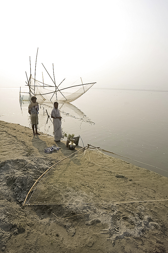 Fisherman and his wife at the rivers edge with nets, Brahmaputra River, Assam, India, Asia