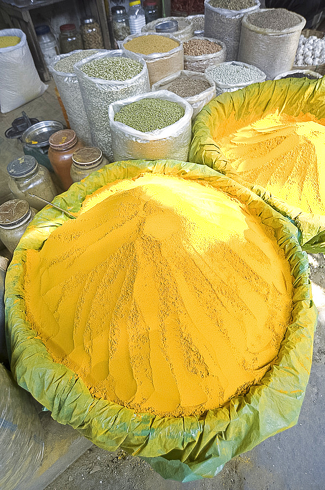 Spice market stall with large bowls of turmeric powder in early morning market on the banks of the Brahmaputra river, Guwahati, Assam, India, Asia