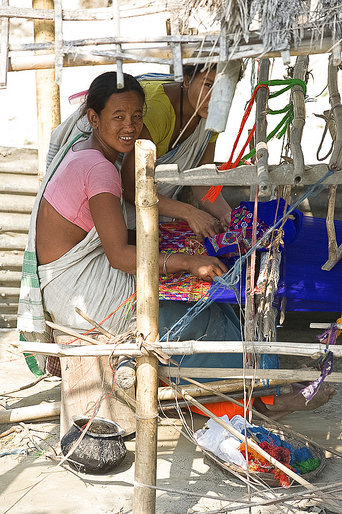 Assamese tribal village women spinning cotton at domestic loom, Majuli Island, Assam, India, Asia