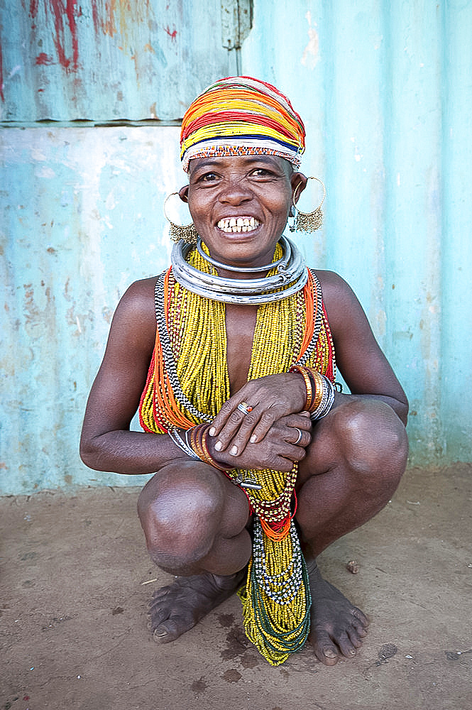 Bonda tribeswoman, smiling, wearing traditional bead costume with beaded cap, earrings and metal necklaces at weekly market, Rayagader, Orissa, India, Asia