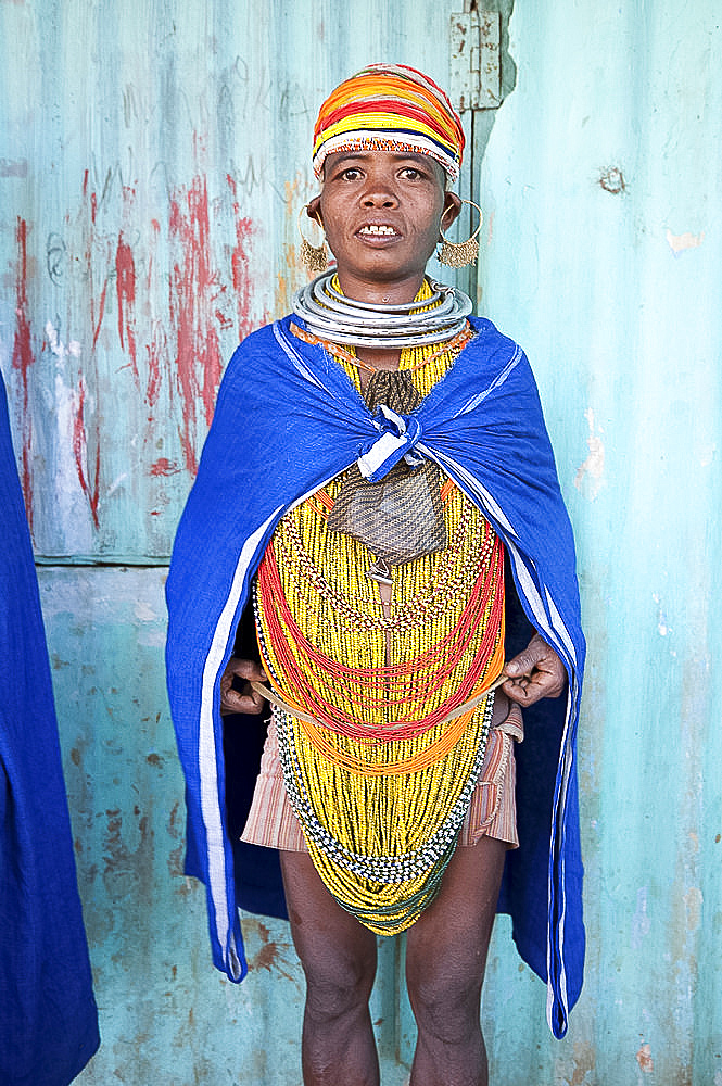 Bonda tribeswoman wearing blue cotton shawl over traditional bead costume, with beaded cap, large earrings and metal necklaces, Rayagader, Orissa, India, Asia