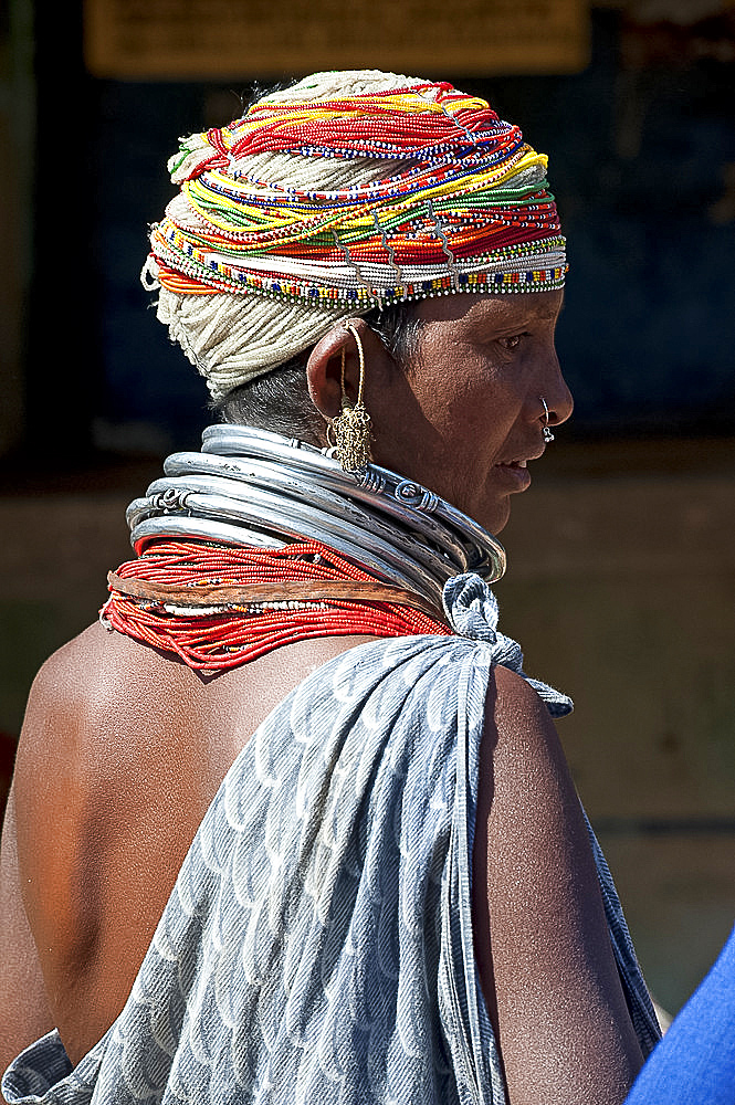 Bonda tribeswoman wearing grey blue cotton shawl and beads with beaded cap, large earrings and metal necklaces at weekly market, Rayagader, Orissa, India, Asia